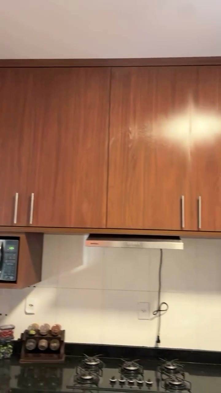 Puxadores metálicos e portas amadeiradas na cozinha