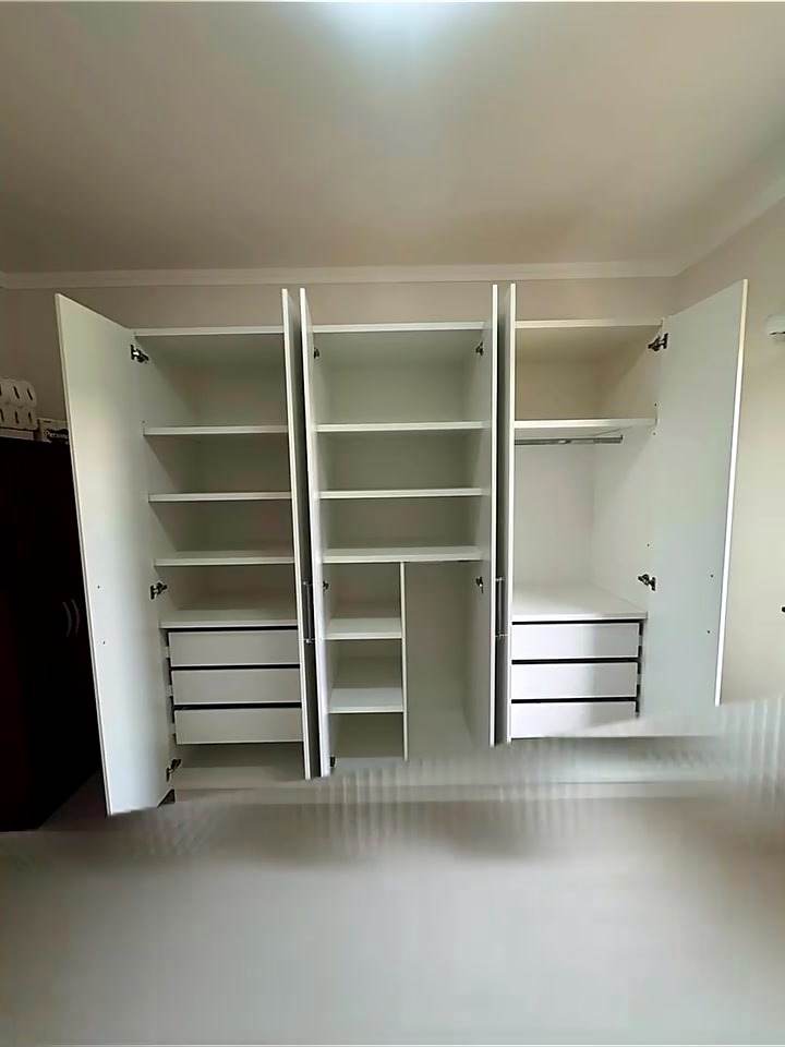 Interior do guarda-roupa branco com prateleiras, gavetas e cabideiros